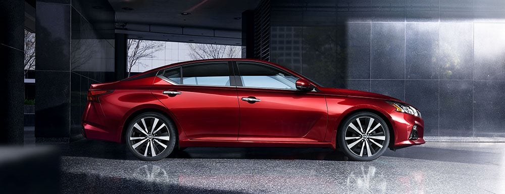 Image of a red 2019 Nissan Altima parked in a dark room.